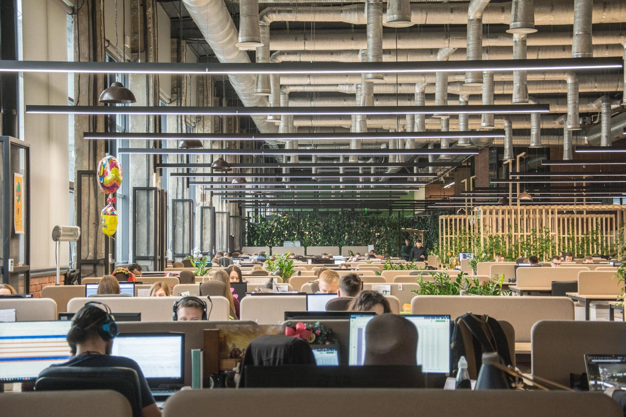 Photograph of modern office space with people working at desks.